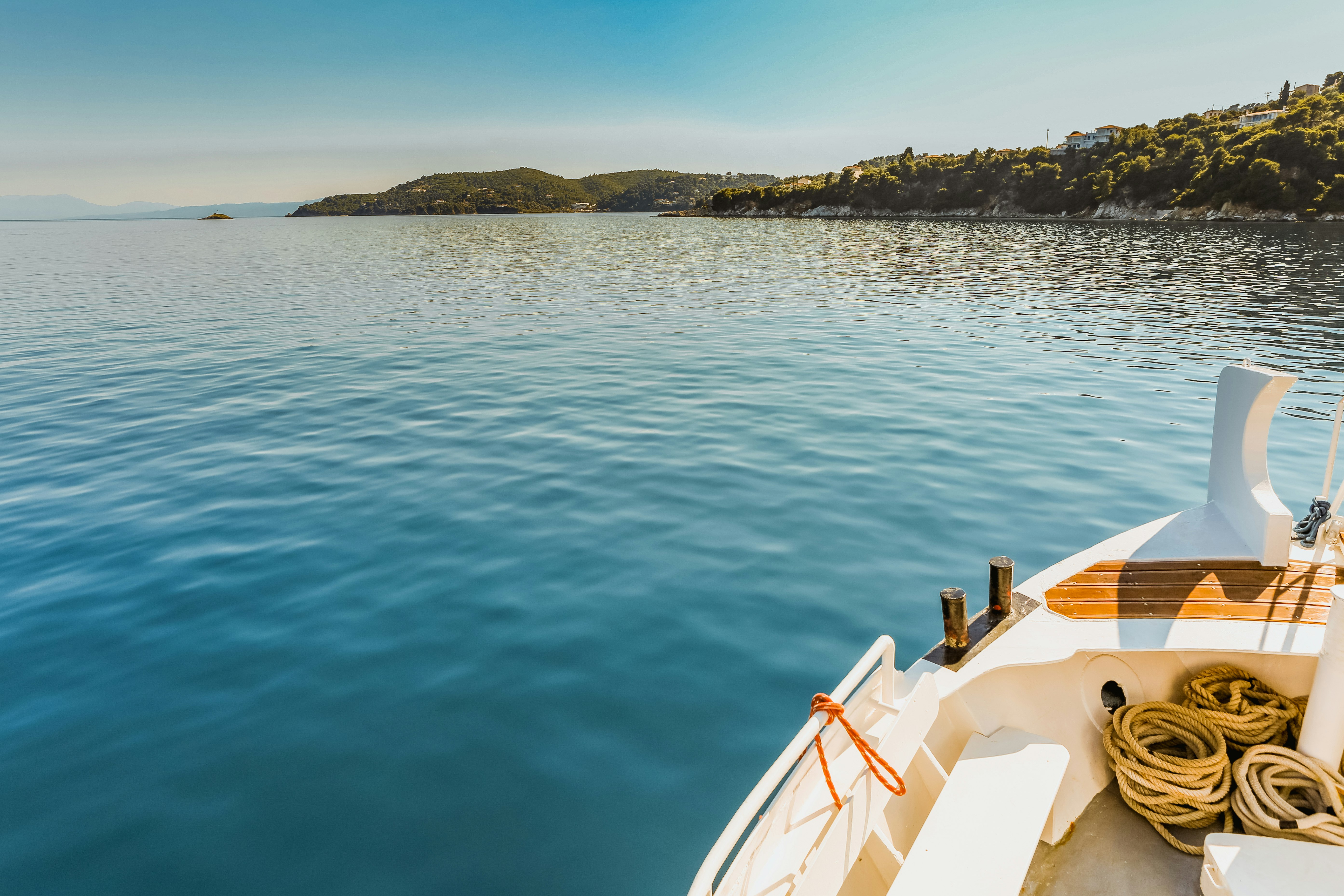 white canoe docked on calm water near island